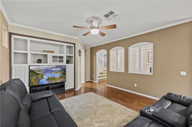 living area featuring a textured ceiling, visible vents, stairway, dark wood-style floors, and crown molding