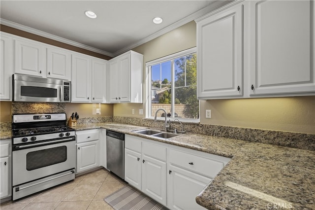 kitchen with crown molding, white cabinetry, stainless steel appliances, and a sink