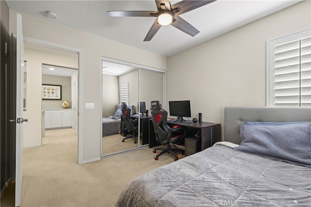 bedroom with light carpet, ceiling fan, baseboards, and a closet