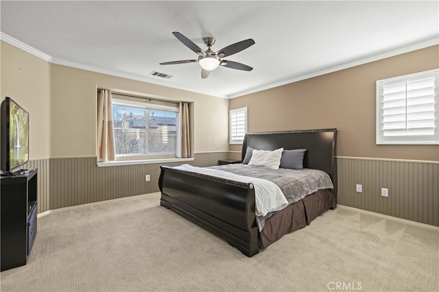 bedroom with a textured ceiling, wood walls, wainscoting, and carpet flooring