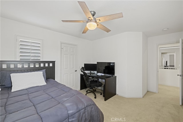 bedroom featuring light carpet, a ceiling fan, and baseboards