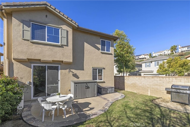 back of property with a patio area, a tile roof, fence, and stucco siding