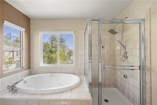 full bath with a stall shower, a garden tub, and plenty of natural light