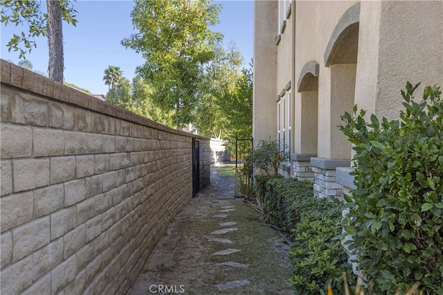 view of side of home with fence and stucco siding