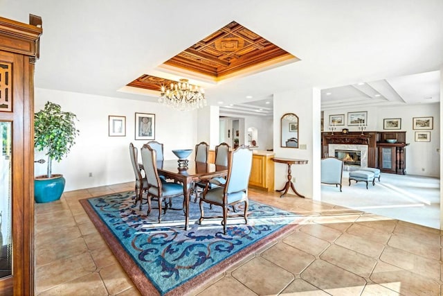 dining area featuring a chandelier, a tray ceiling, light tile patterned flooring, and a premium fireplace