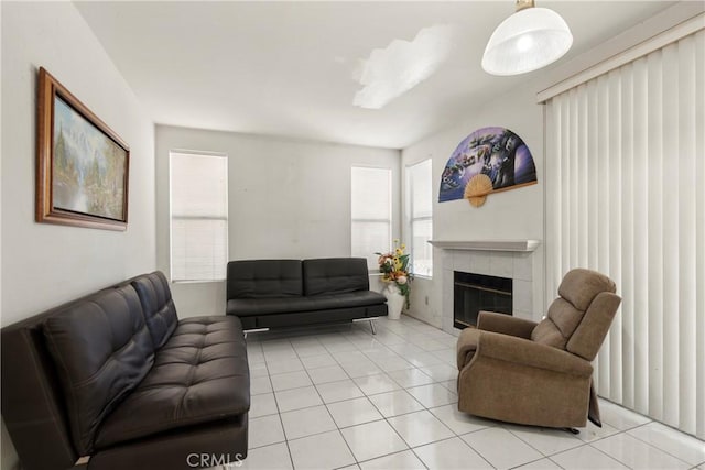 living room with light tile patterned flooring and a tile fireplace