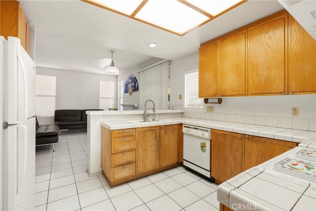 kitchen featuring light tile patterned floors, a peninsula, white appliances, a sink, and open floor plan