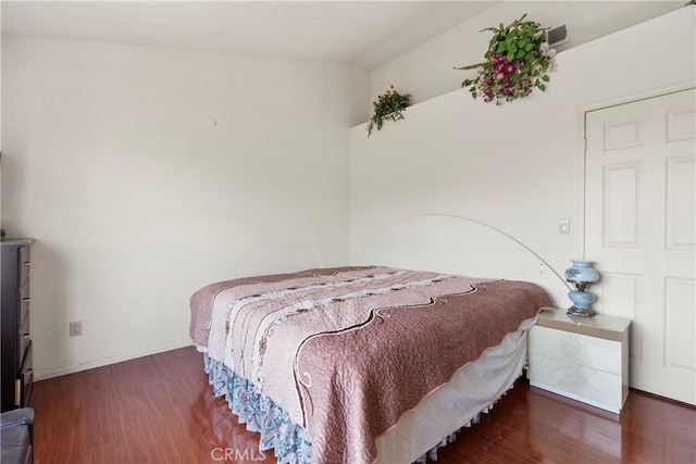 bedroom with baseboards and wood finished floors