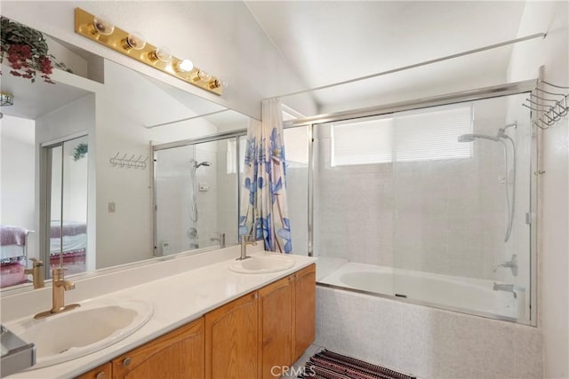 full bathroom with double vanity, tiled shower / bath, a sink, and ensuite bathroom