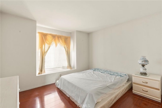 bedroom with baseboards and wood finished floors