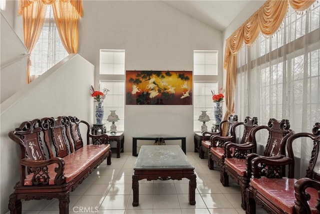 sitting room featuring light tile patterned floors and high vaulted ceiling