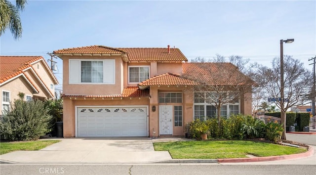 mediterranean / spanish house featuring a garage, driveway, a tiled roof, stucco siding, and a front lawn