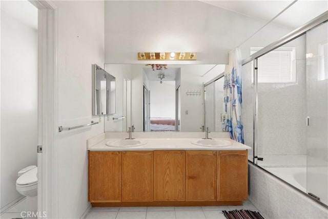 ensuite bathroom featuring a wealth of natural light, a sink, toilet, and double vanity