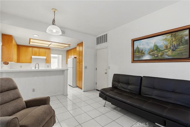 living area with visible vents and light tile patterned floors