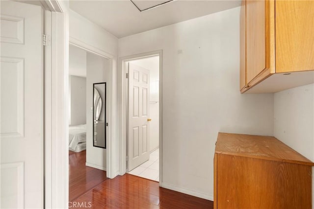 hall featuring dark wood-style floors and baseboards