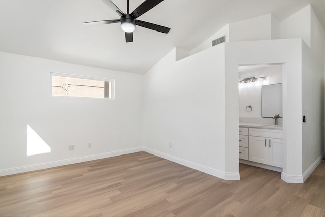 unfurnished bedroom featuring light wood finished floors, visible vents, baseboards, connected bathroom, and lofted ceiling