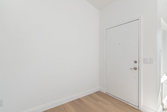 unfurnished room with light wood-type flooring and baseboards