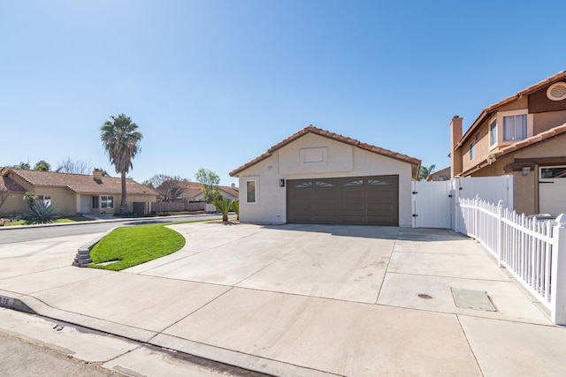 view of front of property with a garage, fence, a residential view, and stucco siding