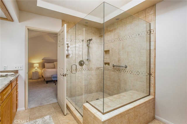 bathroom with a stall shower, baseboards, ensuite bath, tile patterned flooring, and vanity