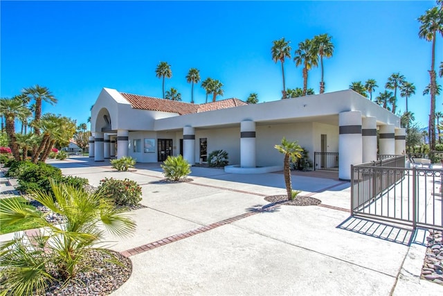 view of front of property with fence, concrete driveway, a tiled roof, a gate, and stucco siding