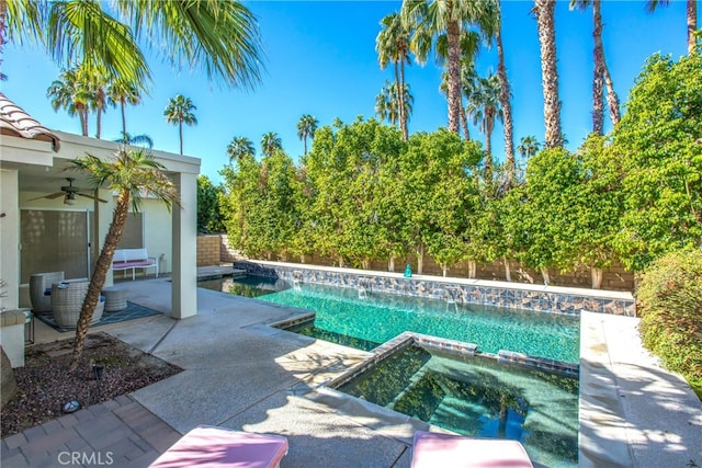 view of pool with a pool with connected hot tub, a fenced backyard, ceiling fan, and a patio