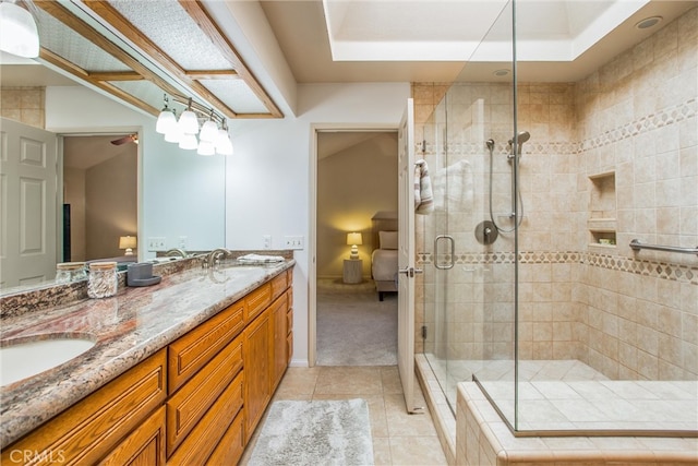 full bathroom featuring double vanity, a shower stall, a sink, and tile patterned floors