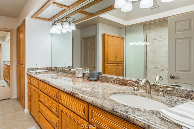 full bath with a shower stall, double vanity, a sink, and tile patterned floors