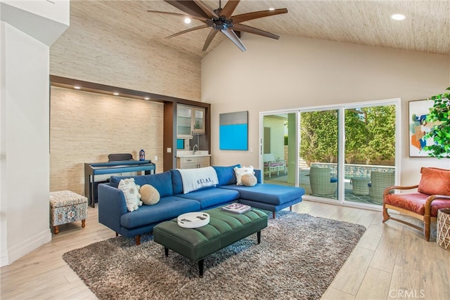 living area with ceiling fan, high vaulted ceiling, recessed lighting, baseboards, and light wood-type flooring