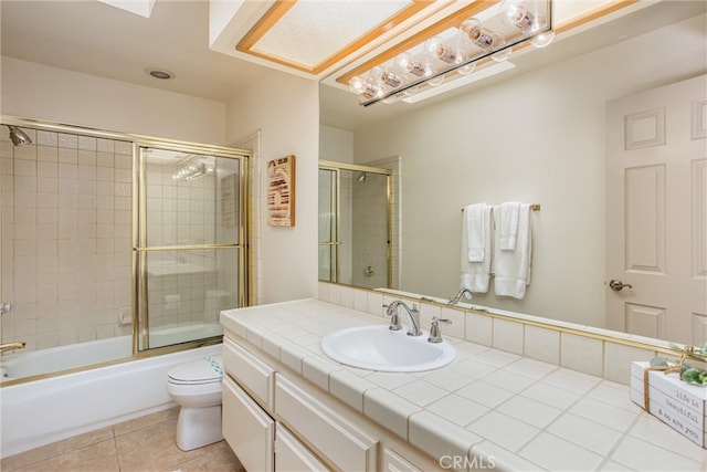 full bath featuring tile patterned floors, vanity, toilet, and bath / shower combo with glass door