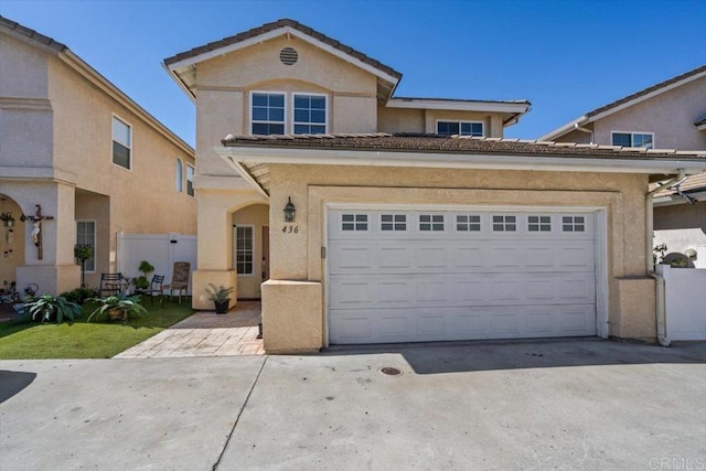 view of front of house featuring driveway, a garage, and stucco siding