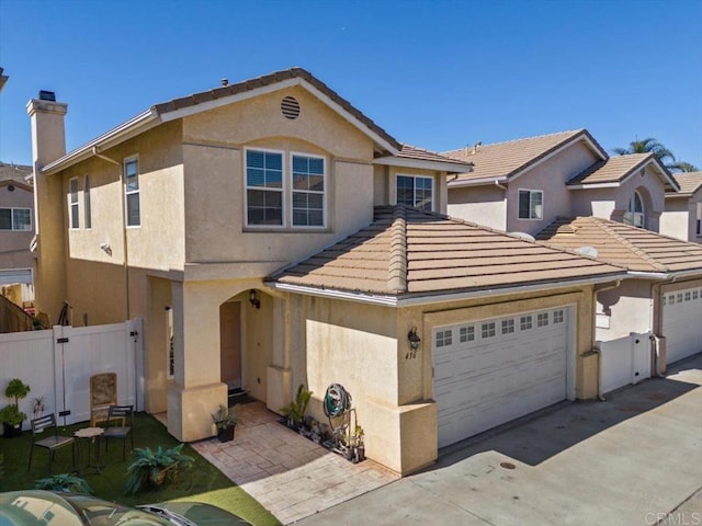 view of front of house with a garage, a tiled roof, driveway, stucco siding, and a chimney