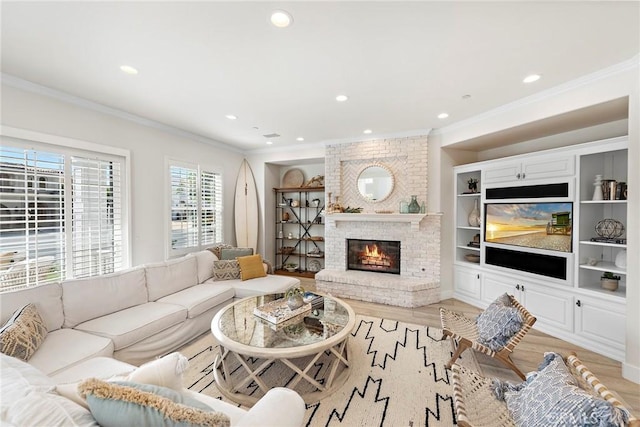 living area with light wood-type flooring, a fireplace, and ornamental molding