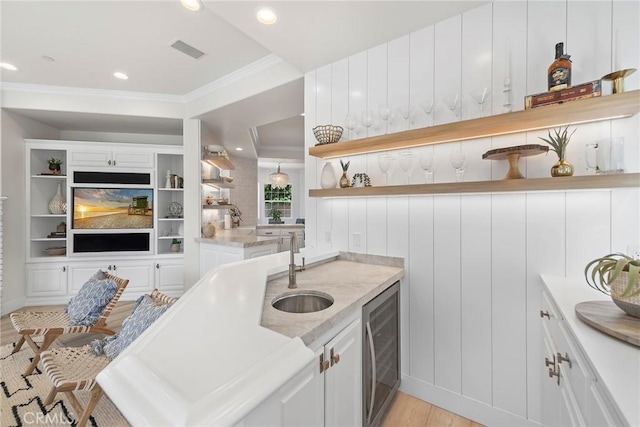 kitchen featuring beverage cooler, open shelves, and white cabinetry