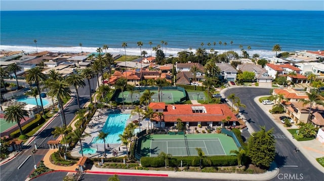 drone / aerial view with a residential view, a water view, and a beach view