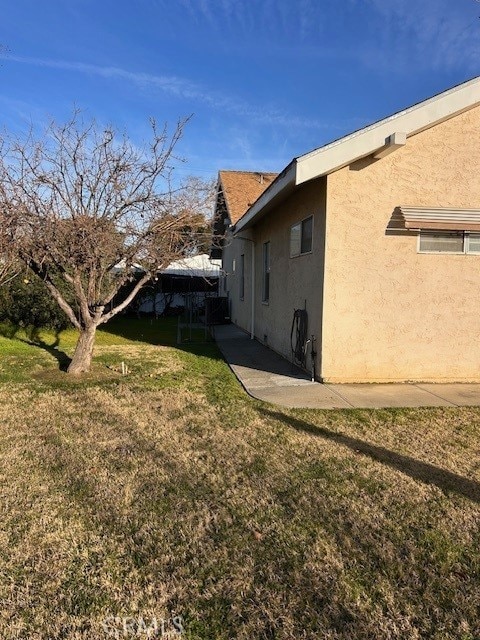 view of home's exterior with a lawn and stucco siding