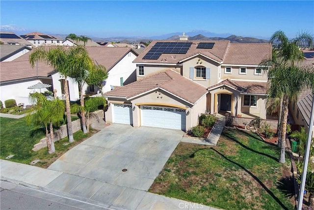 mediterranean / spanish home featuring a garage, solar panels, driveway, a tiled roof, and a residential view