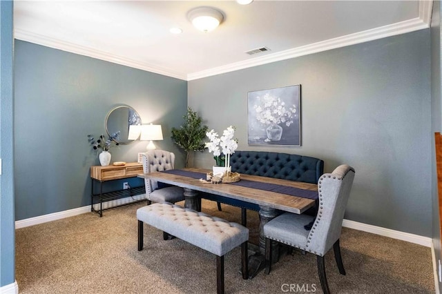 carpeted dining space with baseboards, visible vents, and crown molding