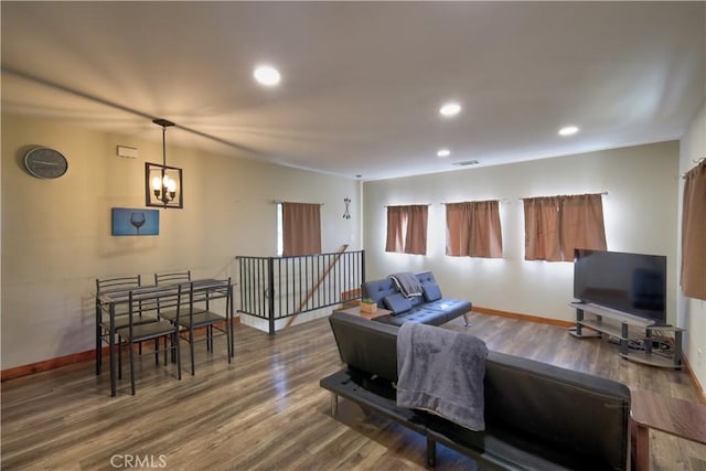 living area featuring a notable chandelier, recessed lighting, wood finished floors, visible vents, and baseboards