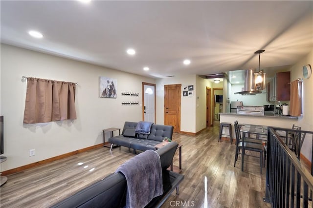 living room with baseboards, wood finished floors, and recessed lighting