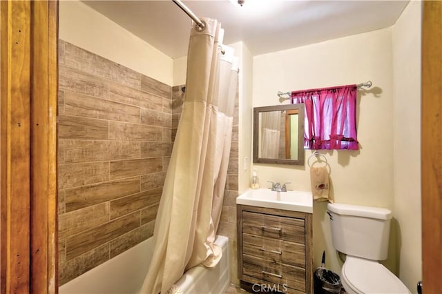 full bathroom featuring toilet, shower / bath combo with shower curtain, and vanity