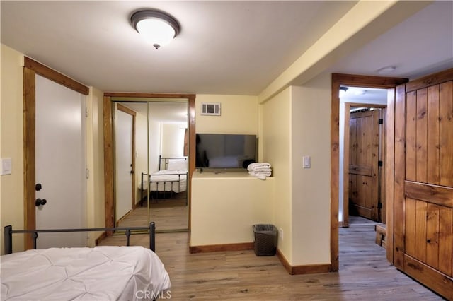 bedroom featuring visible vents, baseboards, and wood finished floors