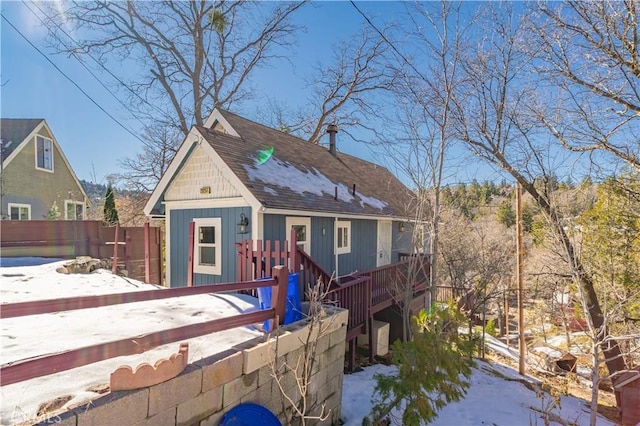 29251 Lake Brook Ave, Cedar Glen, CA 92321 - view of front facade featuring board and batten siding, roof with shingles, fence, and a wooden deck