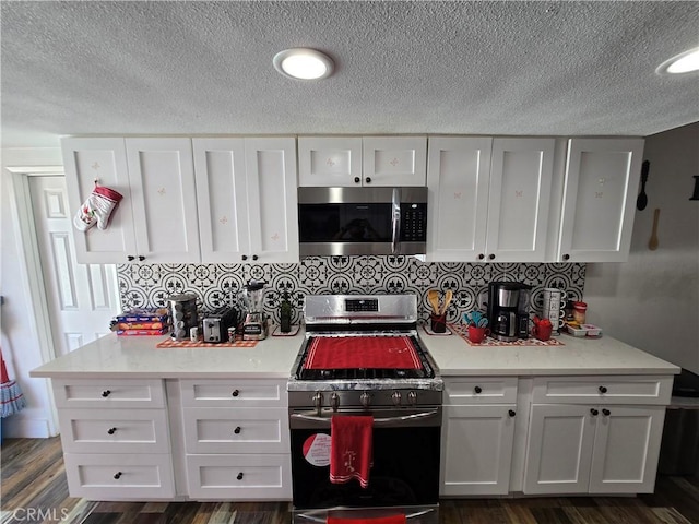 kitchen featuring stainless steel appliances, dark wood-style flooring, and white cabinets