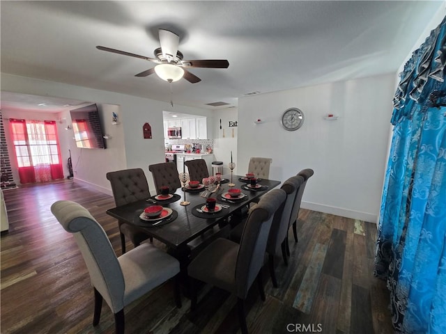 dining room with ceiling fan, dark wood finished floors, and baseboards