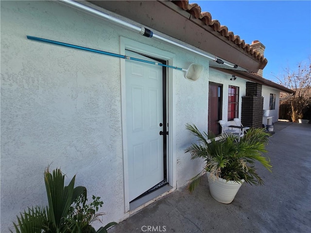 view of exterior entry featuring stucco siding