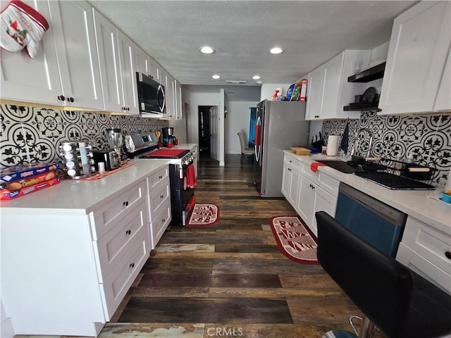 kitchen with dark wood-style floors, stainless steel appliances, light countertops, and white cabinetry