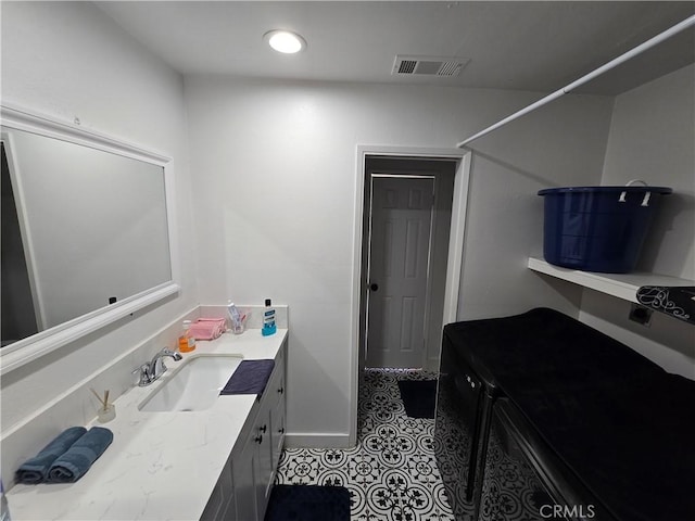 bathroom featuring visible vents, vanity, baseboards, and tile patterned floors