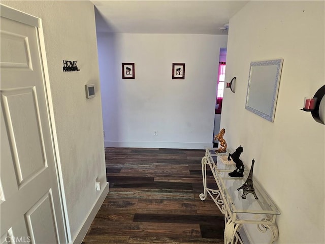 hall with baseboards and dark wood-type flooring