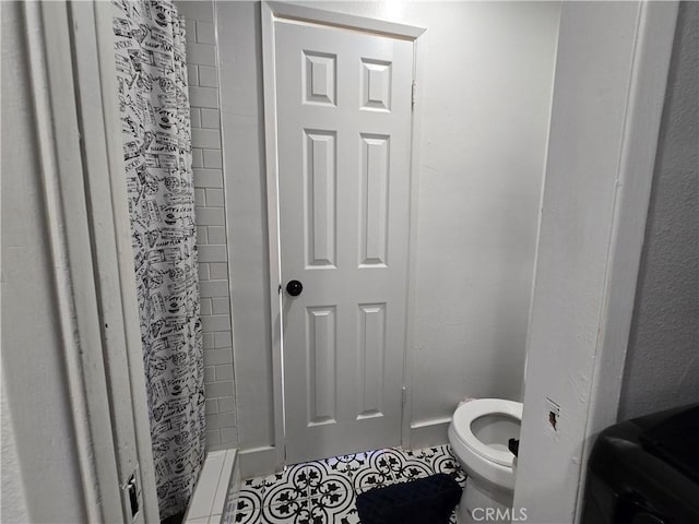 full bath featuring tile patterned flooring, a shower stall, and toilet