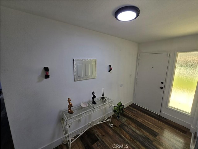 entryway with dark wood finished floors and baseboards